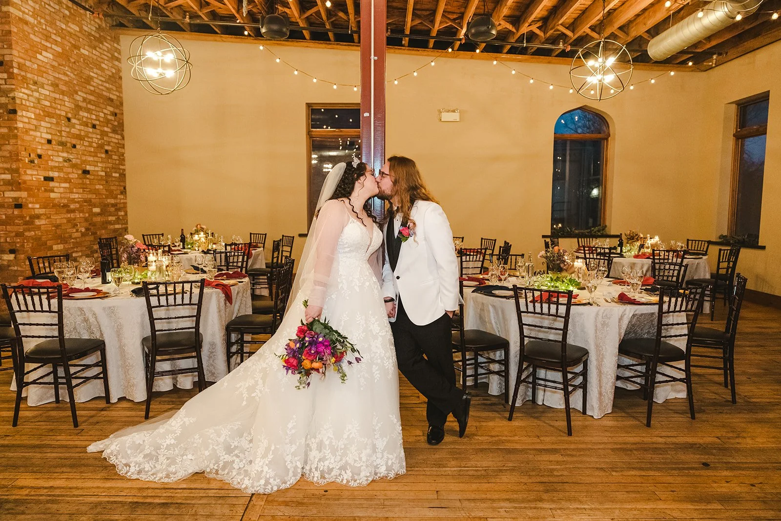 Bride and groom kiss in reception space  Rivers Edge  Paris, ON  Fedora Media.jpg