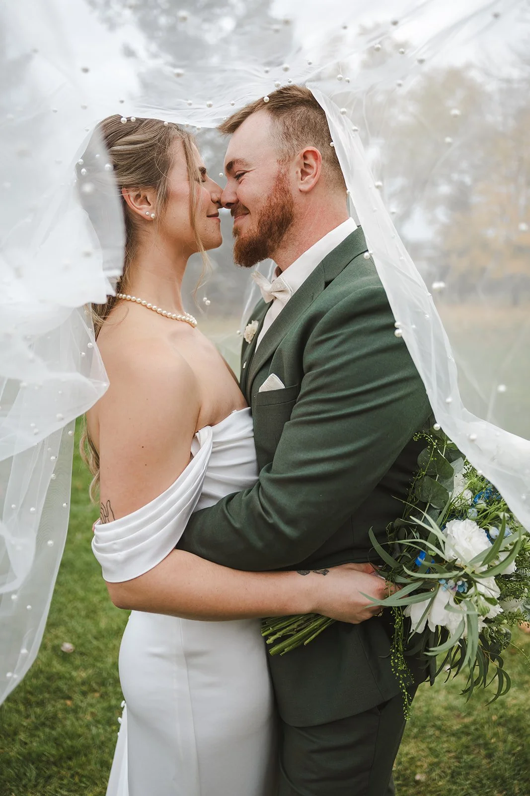 Bride and groom get cozy under veil  fall wedding  Fedora Media.jpg