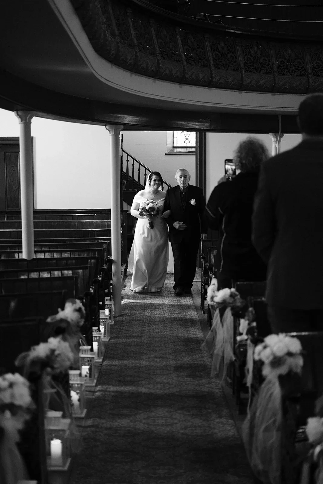 A bride walking down the aisle with her father in a church during a wedding ceremony.