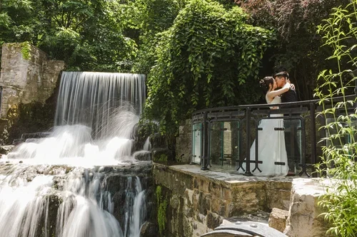 bride+and+groom+kiss+at+Ancaster+waterfall+photo+by+Fedora+Media.webp