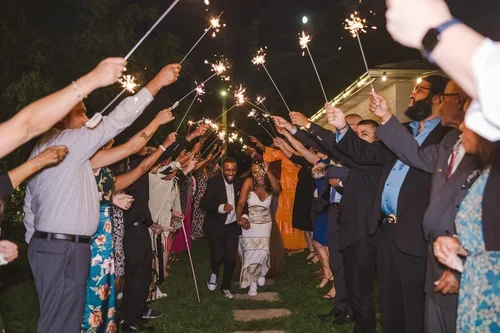 Bride+and+groom+under+tunnel+of+sparklers+at+backyard+wedding+photo+by+Fedora+Media.webp