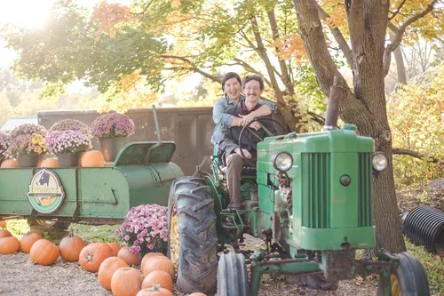 Fall+pumpkin+farm+engagements+shoot+on+tractor+photo+by+Fedora+Media.webp