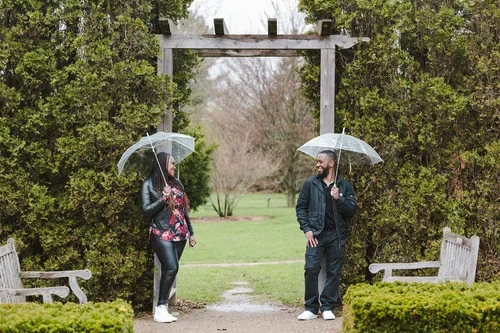Couple+pose+with+umbrellas+at+Guelph+Arboretum+photo+by+Fedora+Media.webp