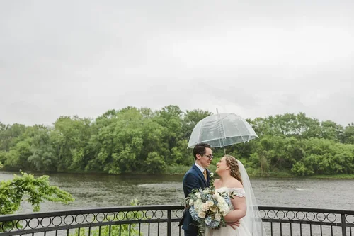 Rain+on+wedding+day+bride+and+groom+under+umbrella+in+Paris+Ontario+photo+by+Fedora+Media.webp