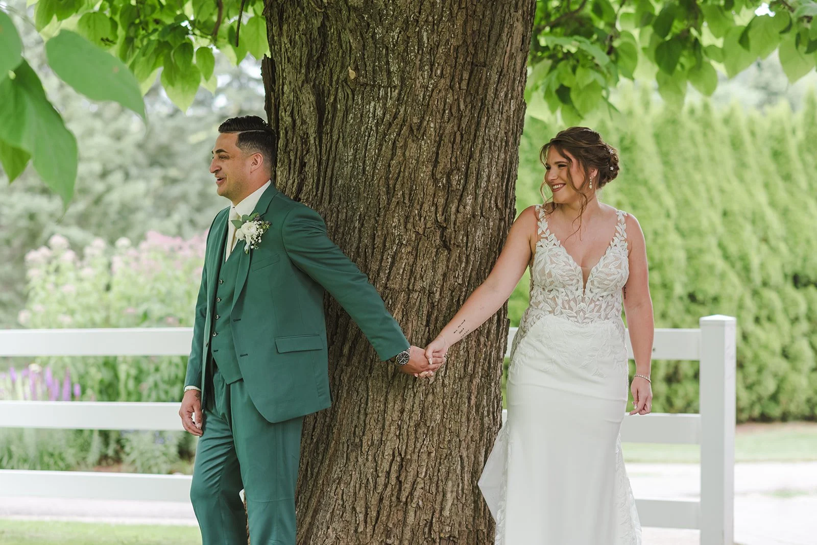 Bride and groom first touch around tree  Springfield Golf & Country Club  Fedora Media.jpg