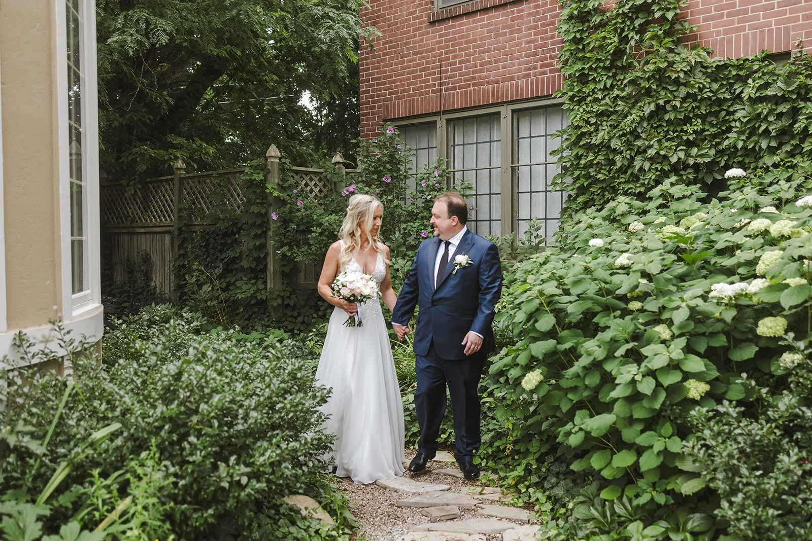 Bride and groom walking in garden  London, ON  Fedora Media.jpg