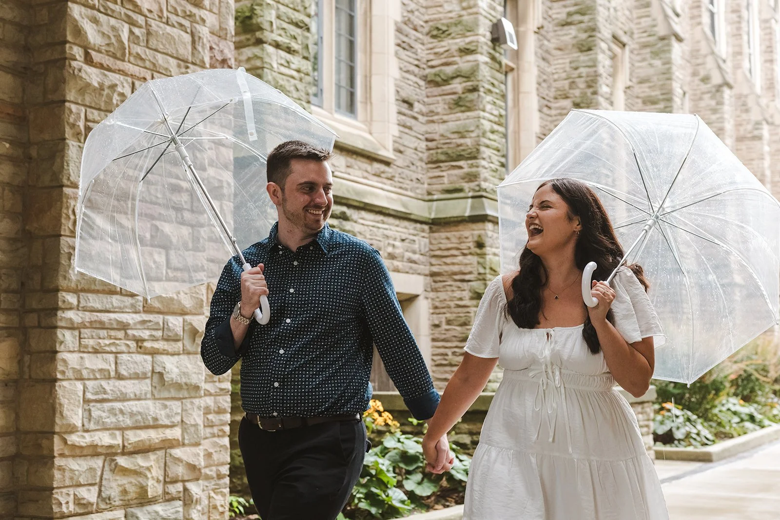Engaged couple laughing with umbrellas  Fedora Media.jpg