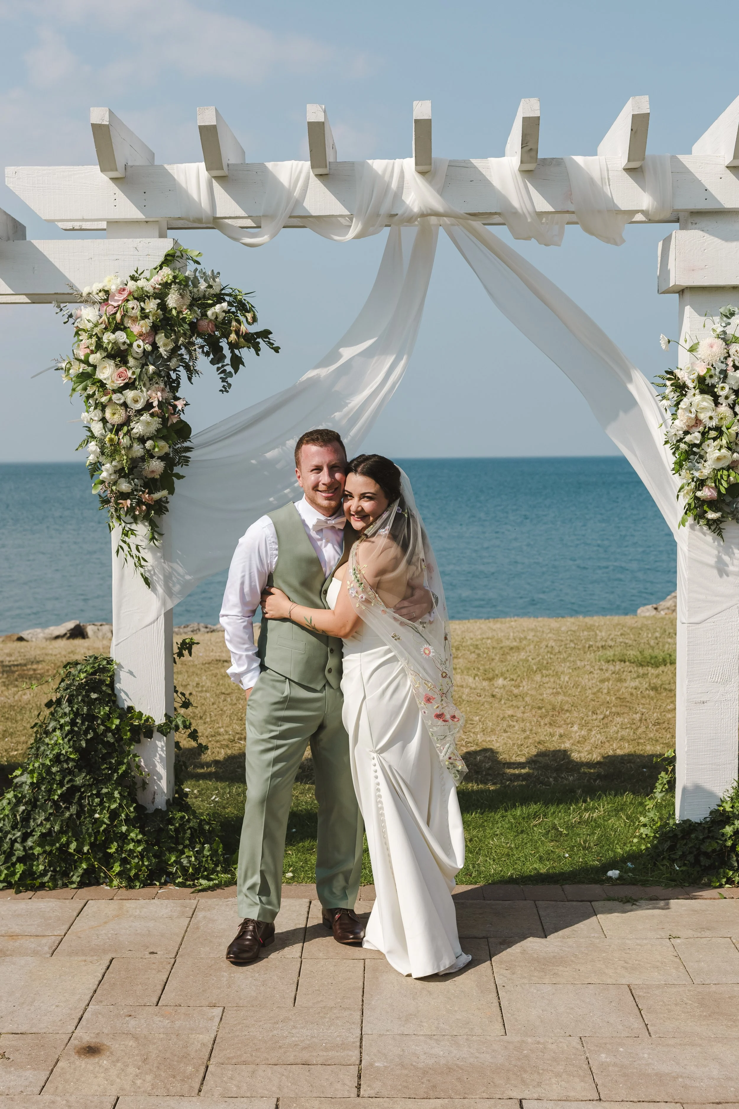 bride-groom-under-arch-by-ocean-fedora-media.jpg