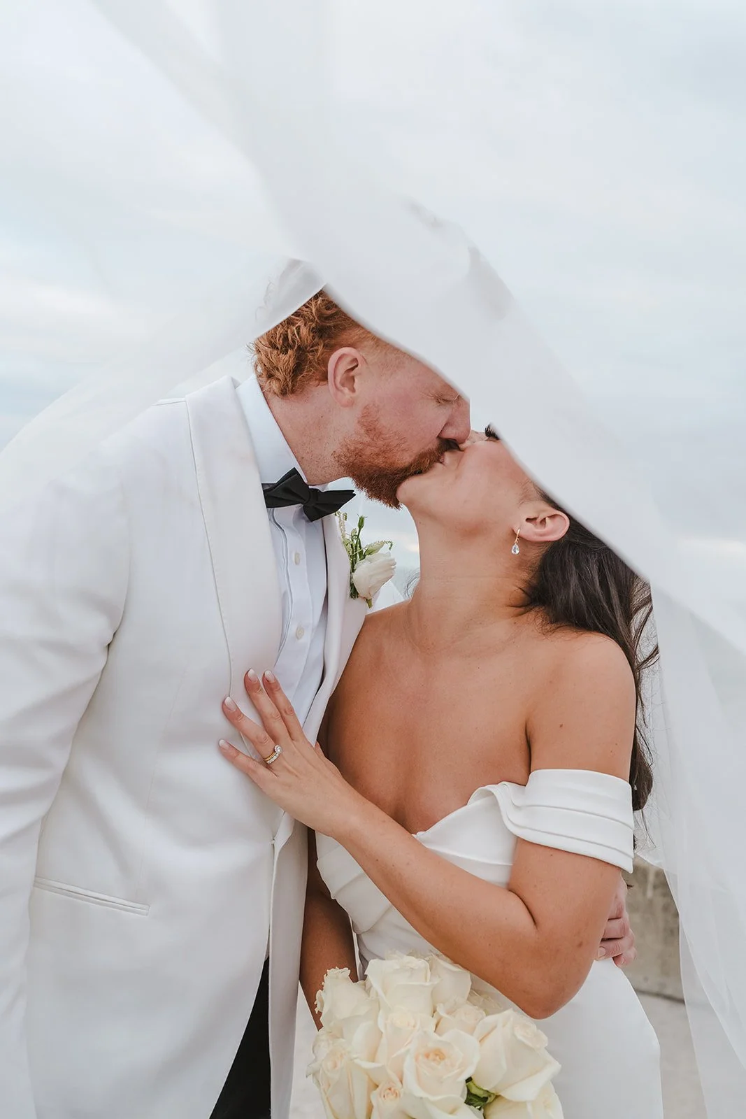 Bride and groom kiss under veil  Spencers at the waterfront  Pearle weddings  Burlington, ON  Fedora Media.jpg