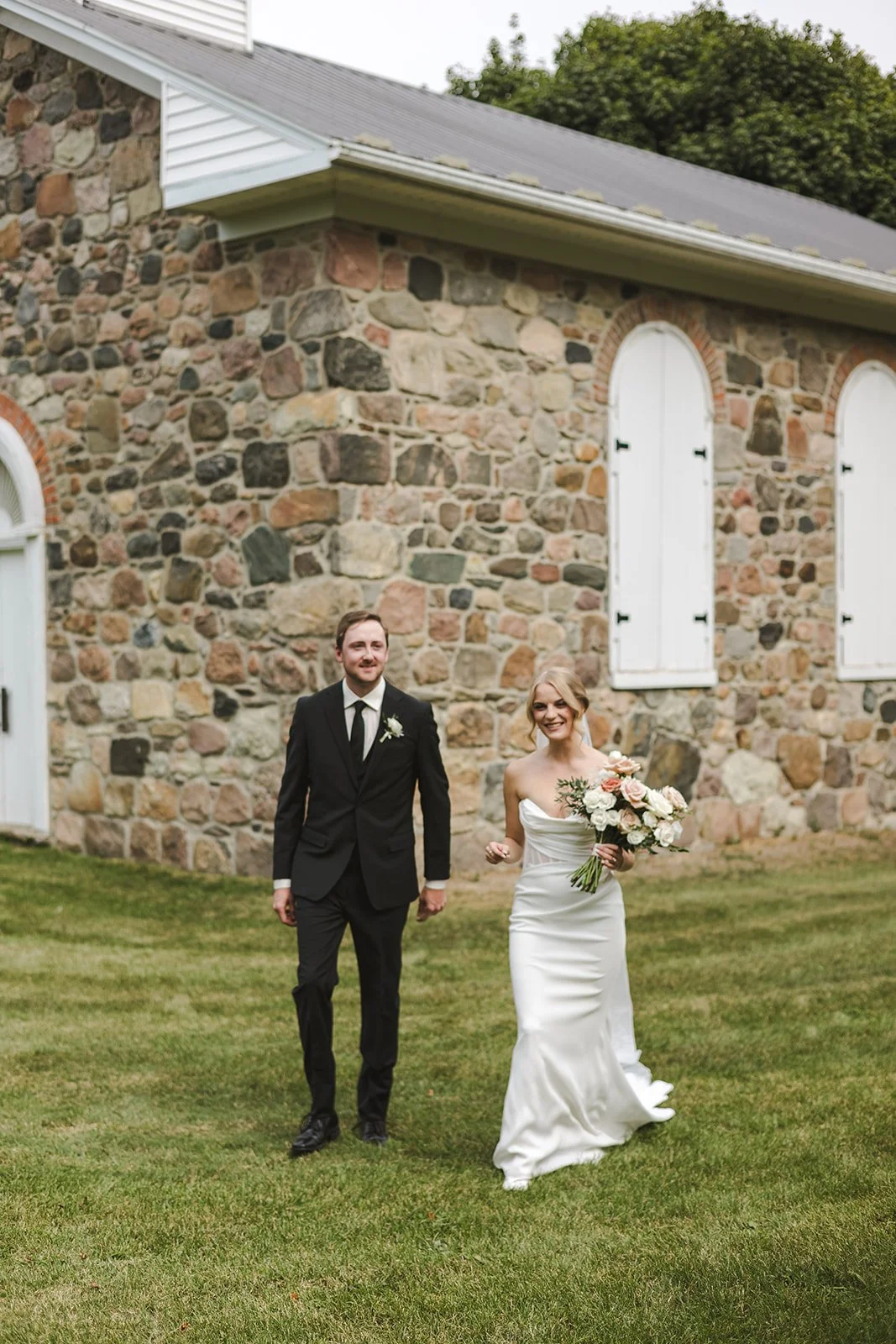 Bride and groom holding hands while walking  Straford, ON  Fedora Media.jpg