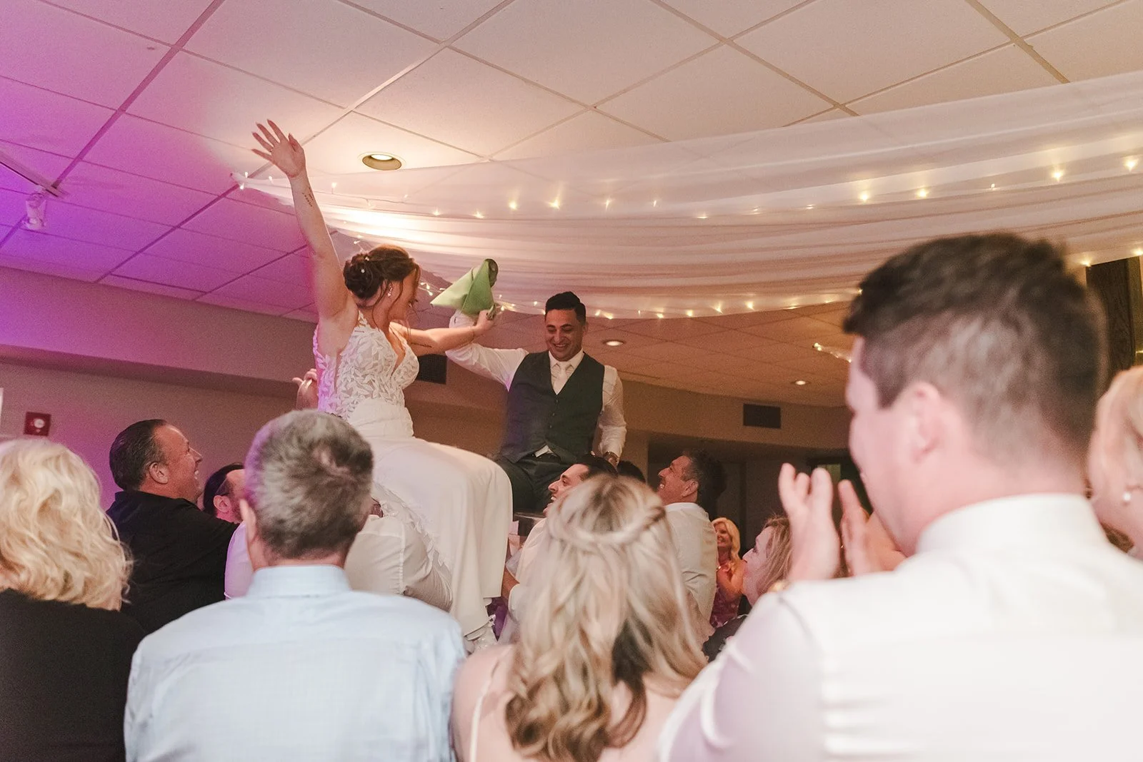 Bride and groom being lifted on chairs during hora  Springfield Golf & Country Club  Fedora Media.jpg