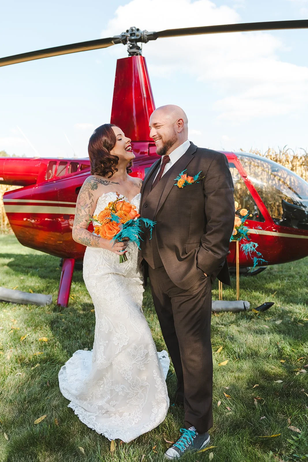 Bride and groom holding bouquet in front of helicopter  Great Lakes Helicopters  Fedora Media.jpg