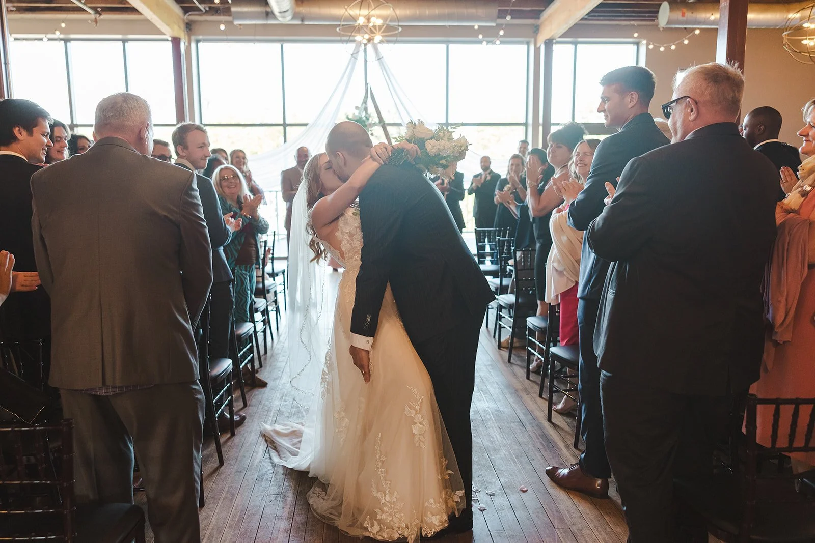 Bride and groom kiss in wedding aisle  Paris, ON  Arlington Hotel  River's Edge  Fedora Media.jpg
