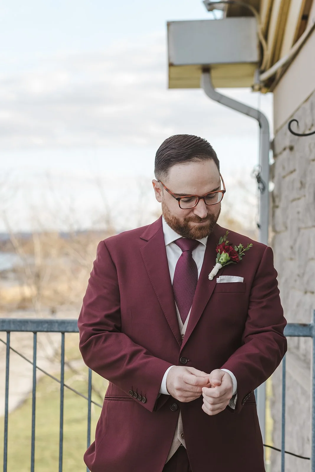Groom adjusting cuffs on balcony  Lakeview By Carmens  Hamilton, ON  Fedora Media.jpg