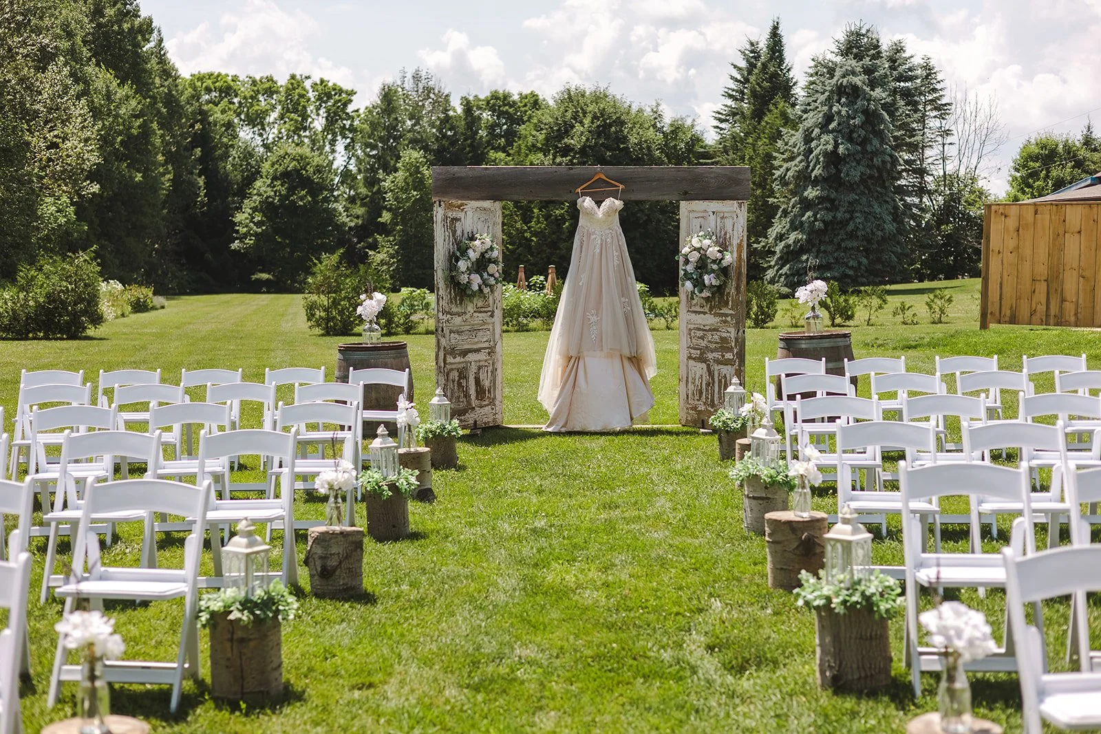 Wedding dress hanging from door frame in field  CJ Country events  Guelph, ON  Fedora Media.jpg