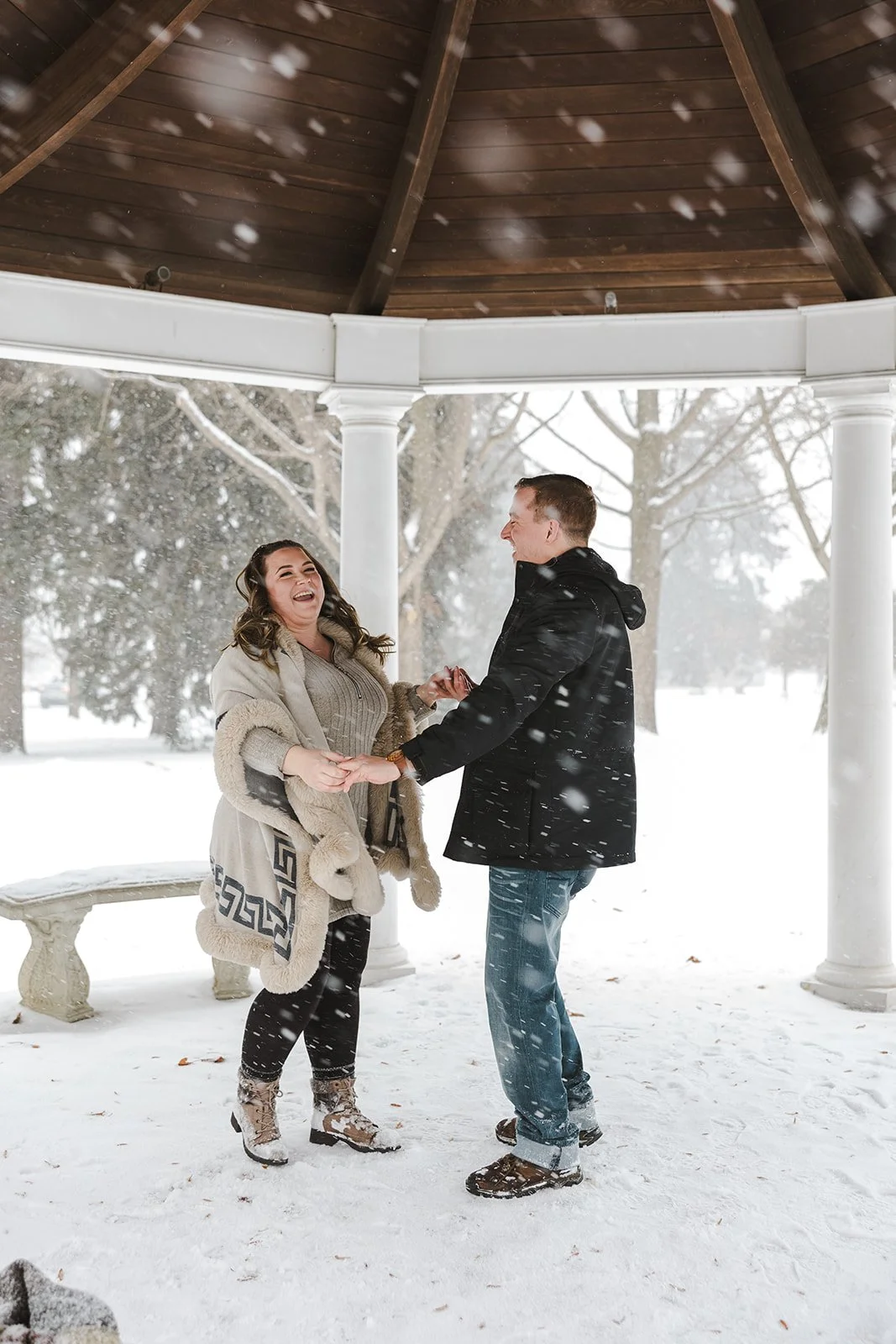 Couple dancing under snowy gazebo  Ontario Engagement  Fedora Media.jpg