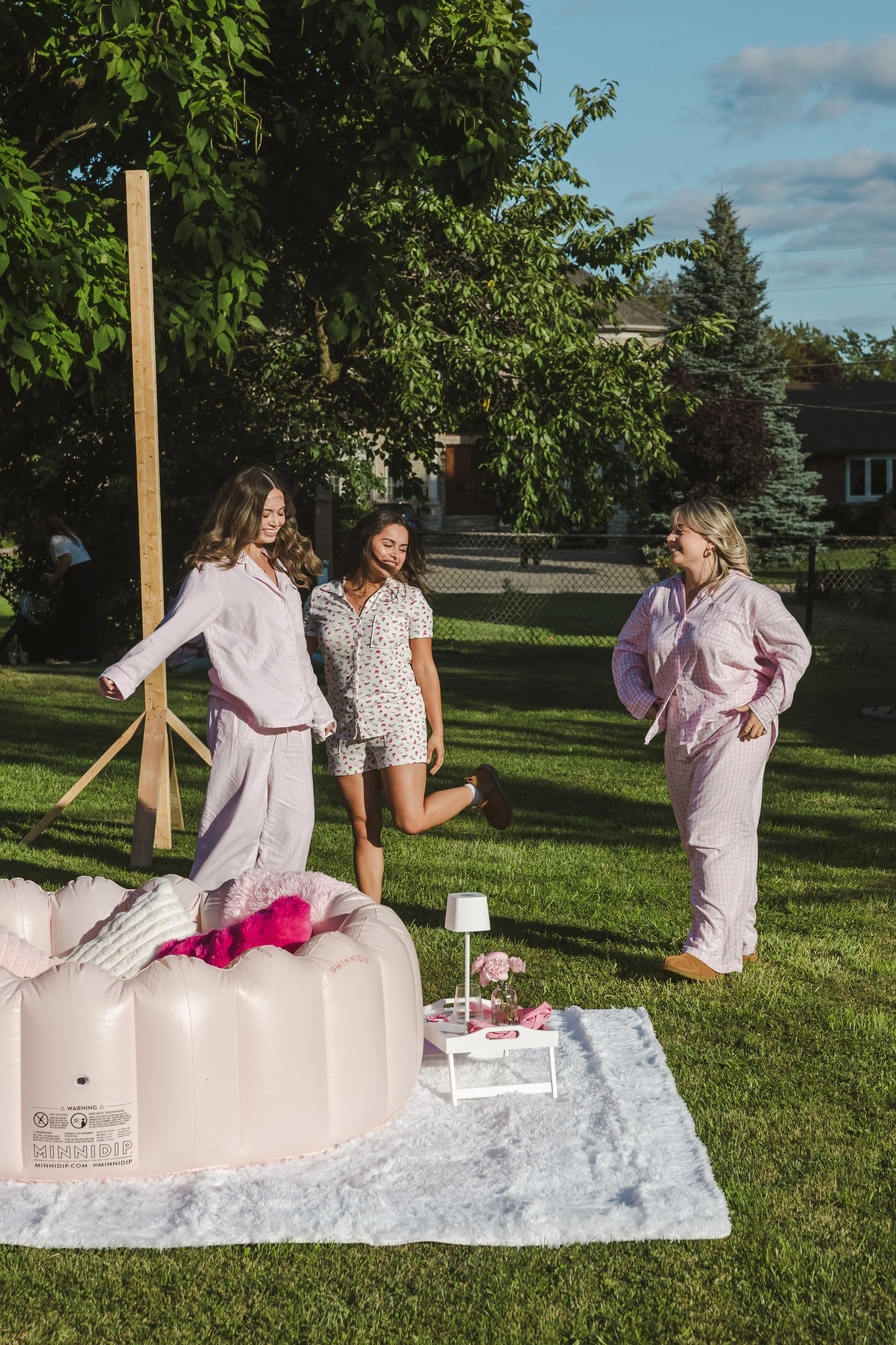 women-wearing-pink-pjs-standing-on-grass-movie-night-fedora-media.jpg