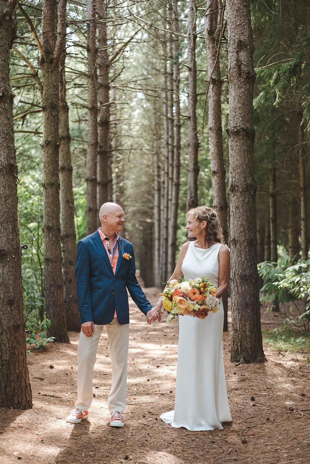Bride and groom holding hands in forest  Erin Estates  Fedora Media.jpg