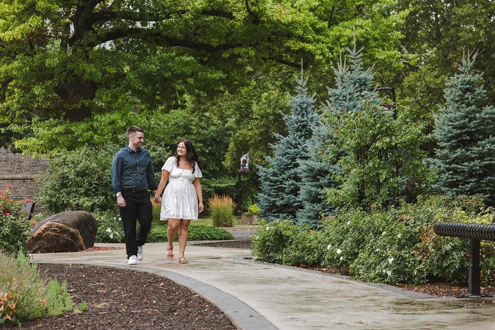Engaged couple walking on pathway  Fedora Media.jpg