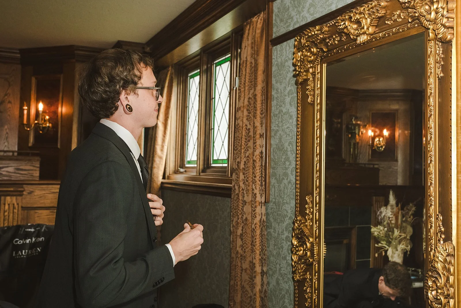 Groom checking his tie in the mirror  Erin Estates  Fedora Media.jpg