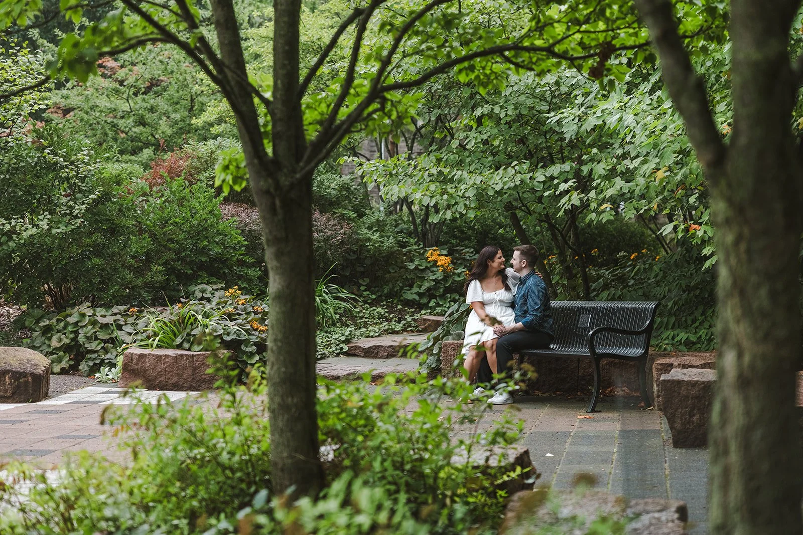 Engaged couple sitting on park bench  Fedora Media.jpg