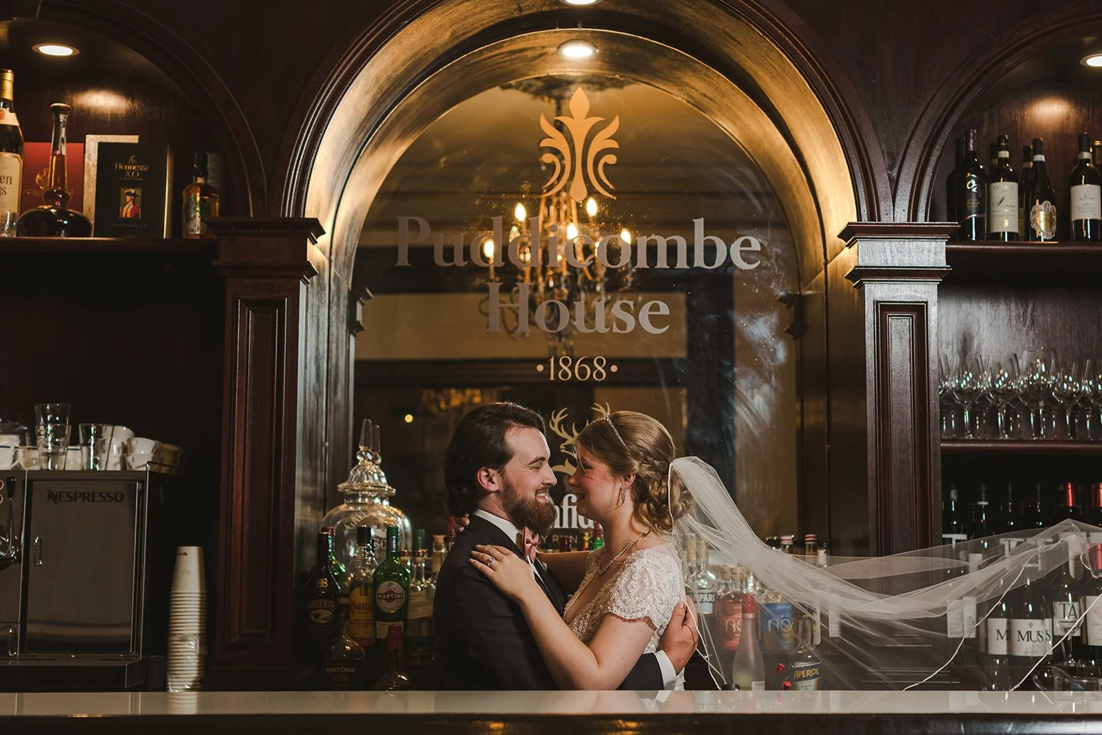Bride and groom embracing behind bar  Puddicombe House  New Hamberg, ON  Fedora Media.jpg