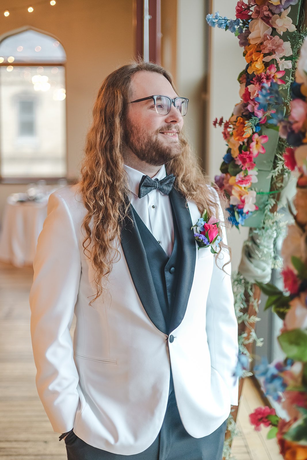 Groom in white suit starring out window  Rivers Edge  Paris, ON  Fedora Media.jpg