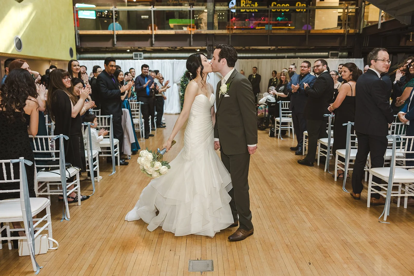 Bride and Groom kiss in wedding aisle  Kitchener, ON  THE museum  Fedora Media.jpg