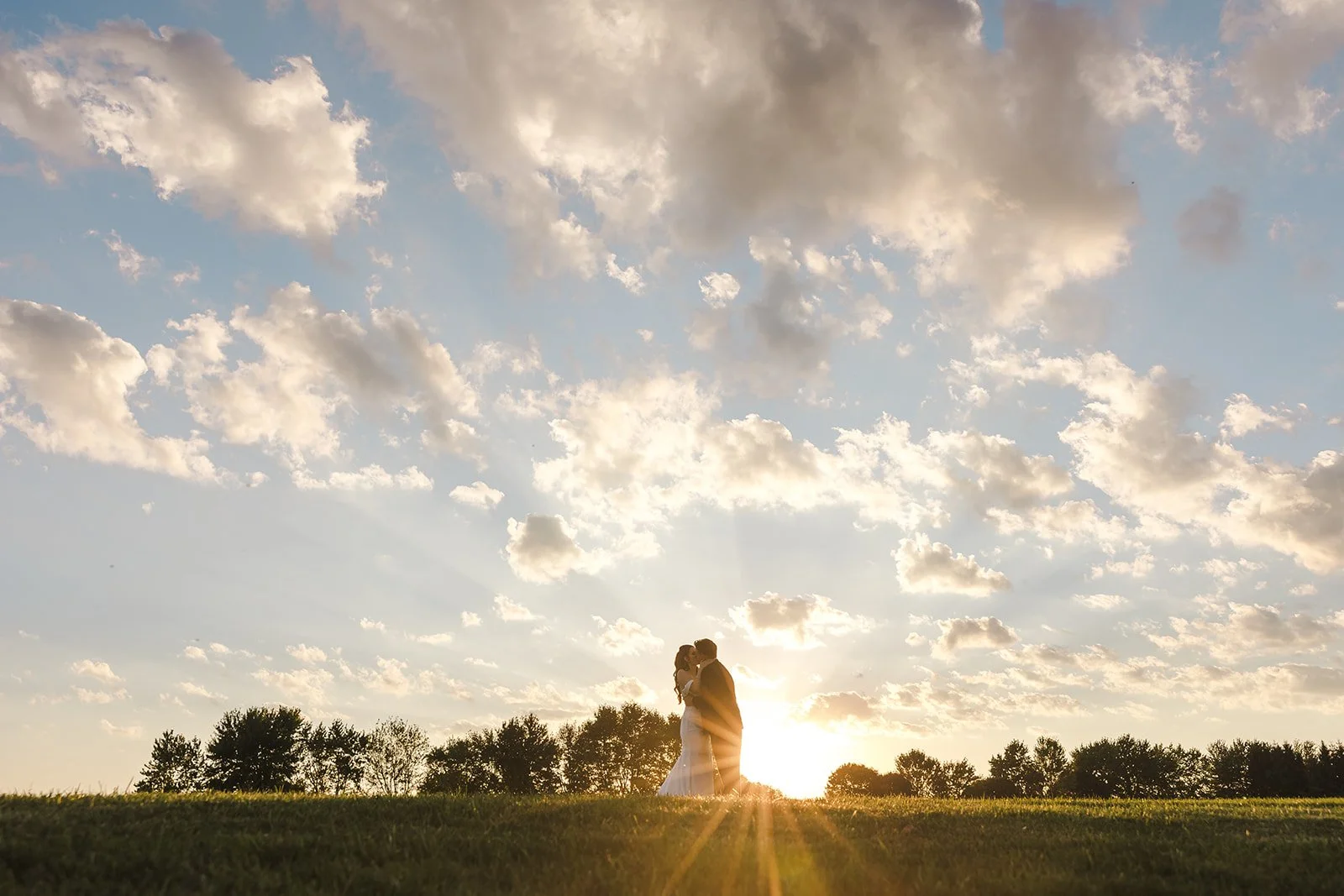 Bride and groom kissing at sunset  Barn Swallows at Thatcher Farm  Fedora Media.jpg