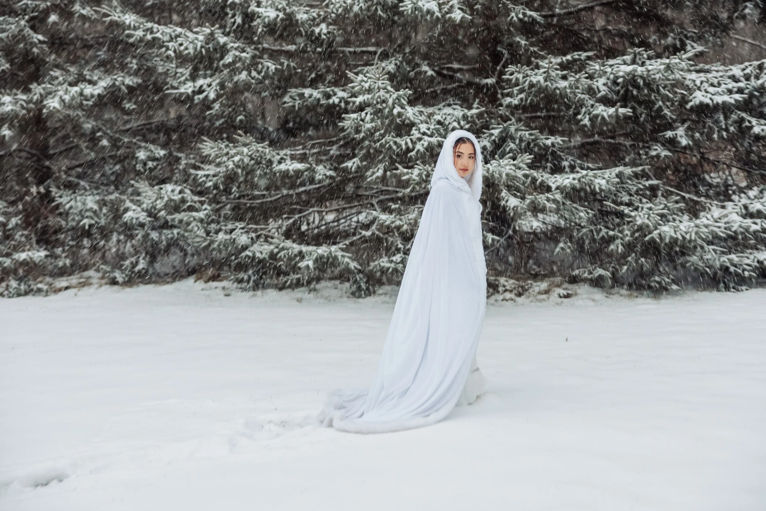 bride-with-white-gown-and-white-hood-in-snow-erin-estate-fedora-media.jpg