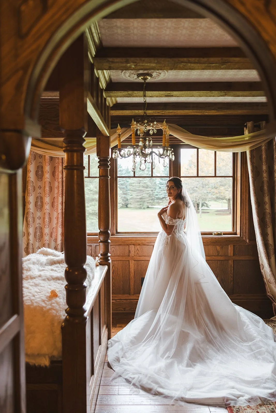 Bride in dress looking over shoulder in bridal suite  Erin Estates  Fedora Media.jpg