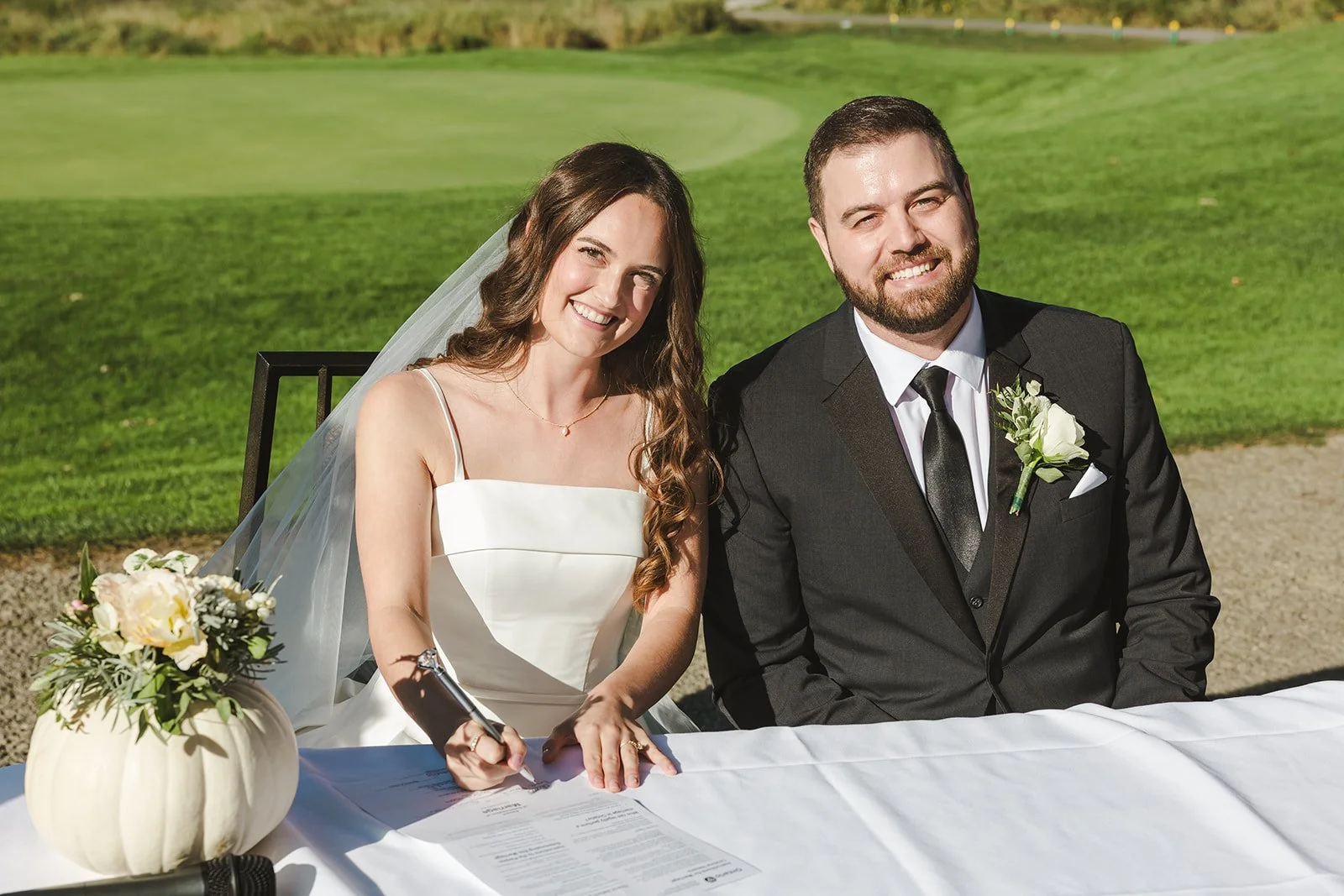 Bride and groom smile while signing marriage certificate Century Pines  Fedora Media.jpg