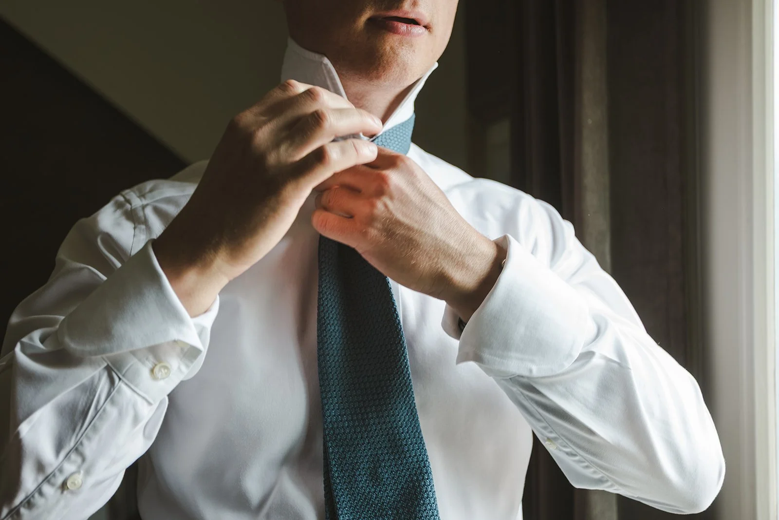 Groom tying tie  River's Edge  Arlington Hotel  Paris, ON  Fedora Media.jpg