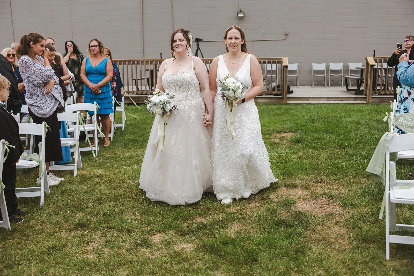 Brides walk down aisle together on wedding day  Cambridge, ON  Newfoundland Club  Fedora Media.jpg