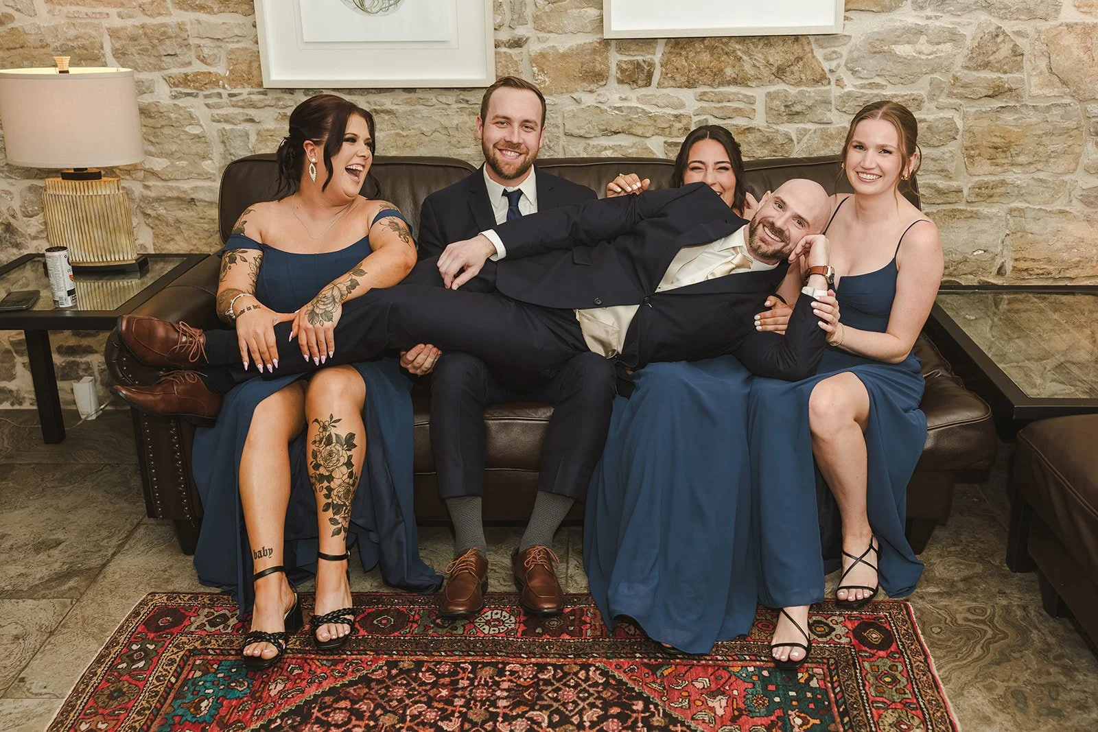 Groom laying on couch with wedding party  Dundas Valley  Fedora Media.jpg