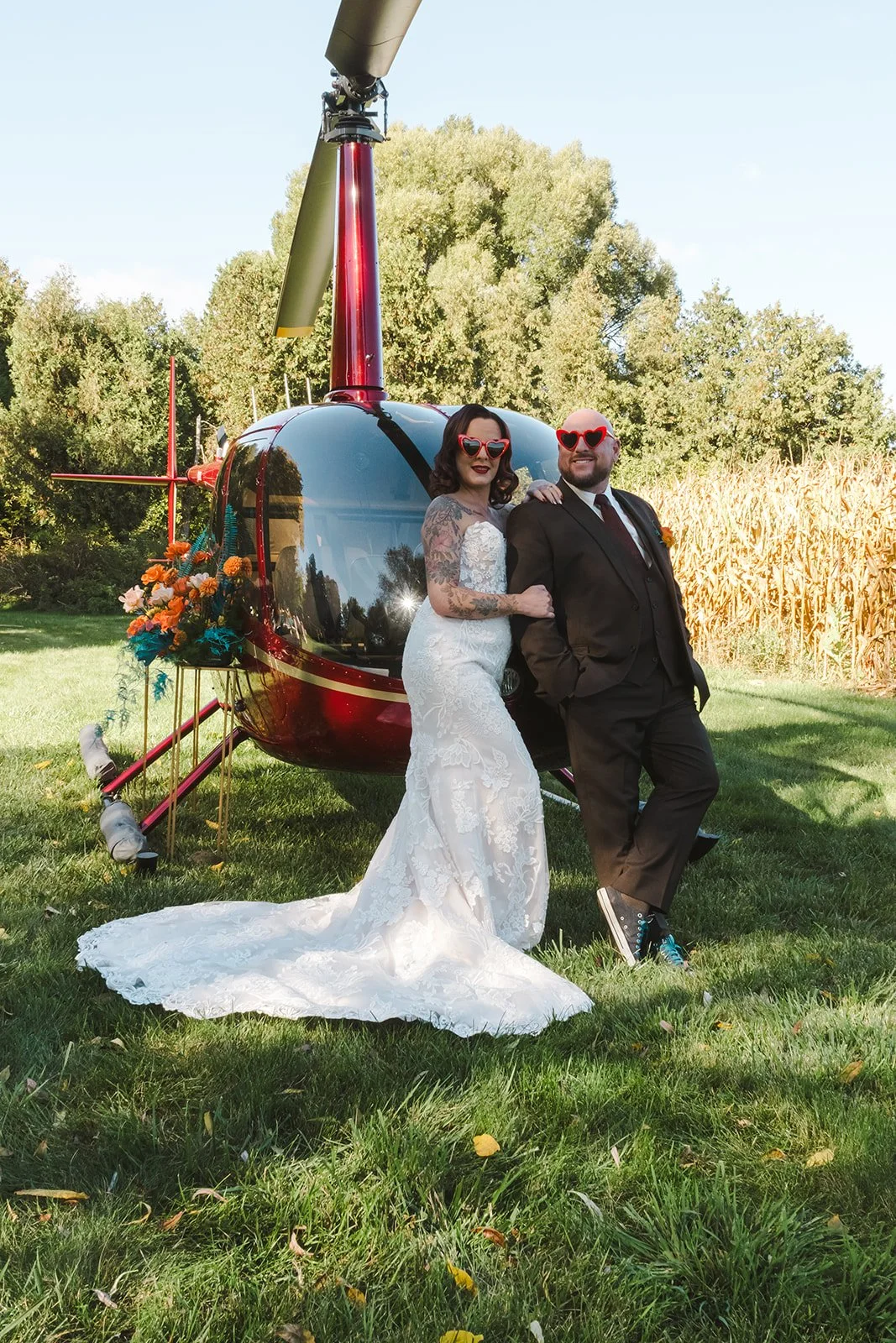 Bride and groom posing with teal flower arrangement in front of helicopter  Great Lakes Helicopters  Fedora Media.jpg