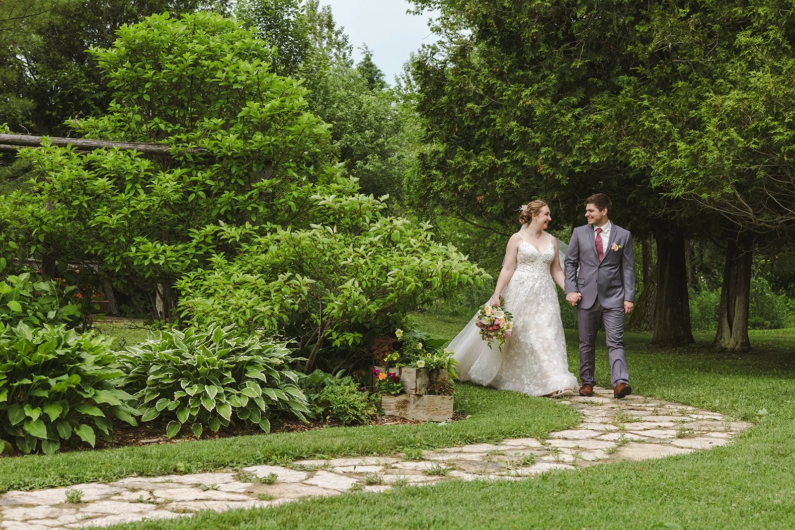 Bride and groom walking on stone path  Boho Wedding  Fedora Media.jpg