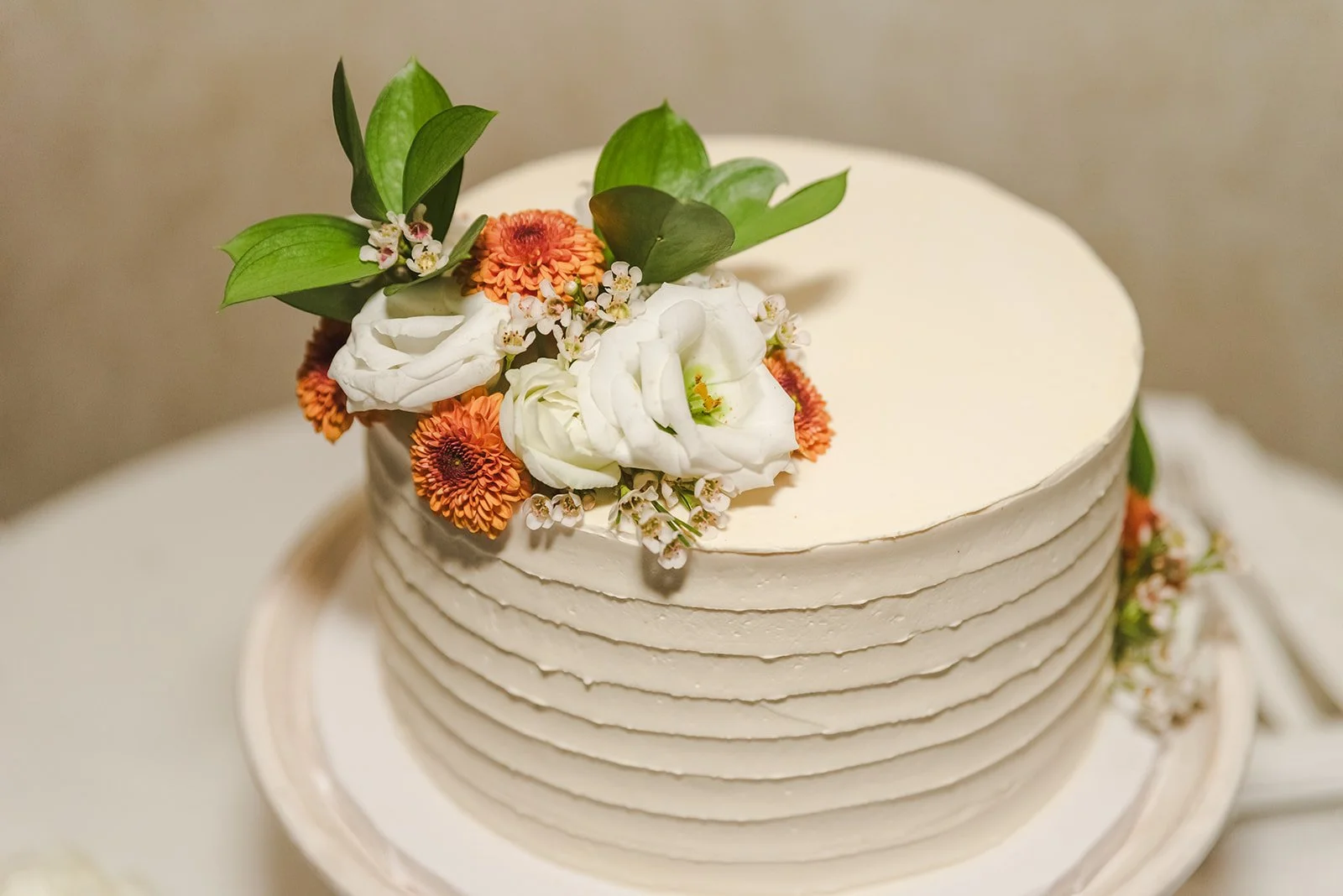 White wedding cake with orange and white flowers  Ancaster,  ON  Ancaster Mill  Fedora Media.jpg