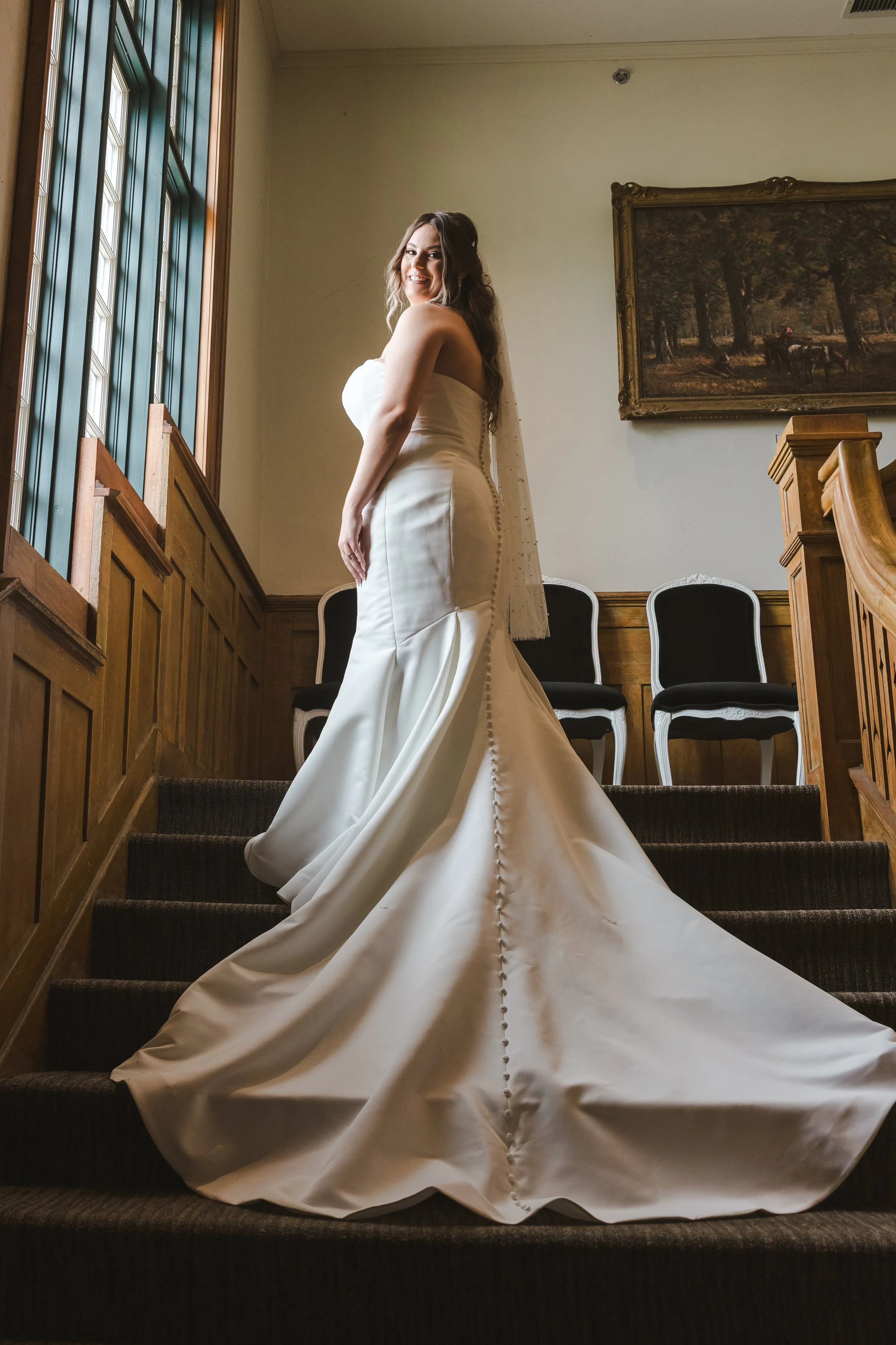 bride-on-stairs-with-sunlight-wedding-dress-fedora-media.jpg