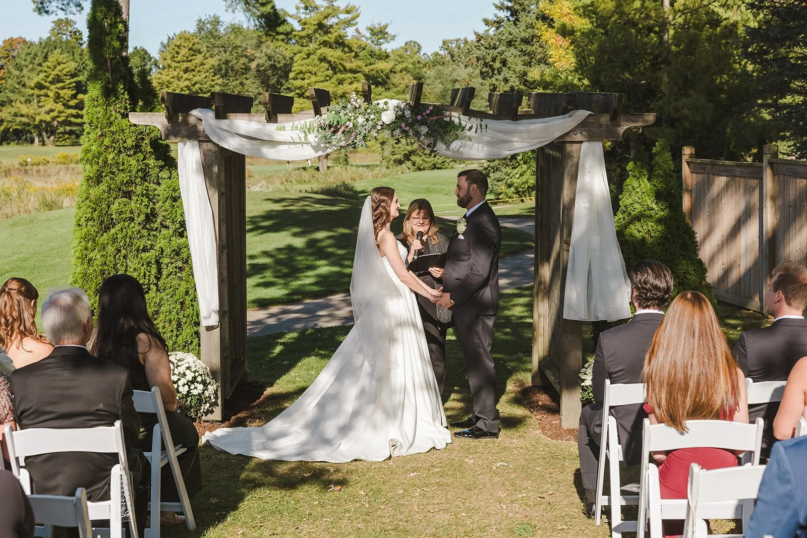 Bride and groom hold hands during wedding ceremony Century Pines  Fedora Media.jpg