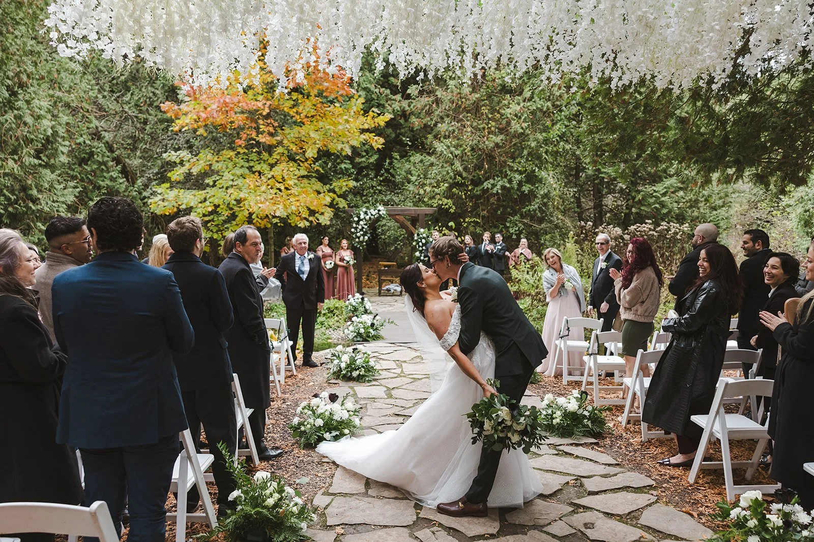 Bride and groom dip kiss in aisle surrounded by guests  Erin Estates  Fedora Media.jpg