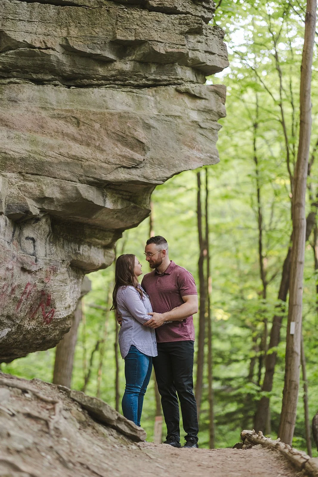 Couple embracing beside rock wall  Ontario Engagement  Fedora Media.jpg