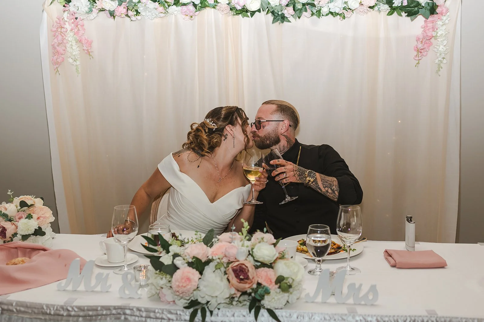 Bride and groom kiss at head table with drinks  Puddicombe House  New Hamberg, ON  Fedora Media.jpg