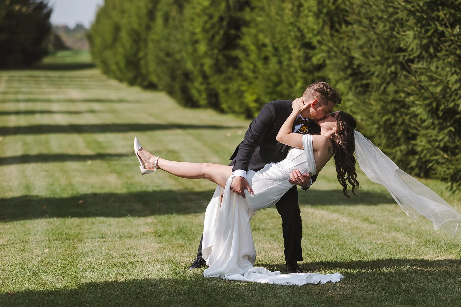 Groom dip kiss with bride  Barn Swallows at Thatcher Farm  Fedora Media.jpg