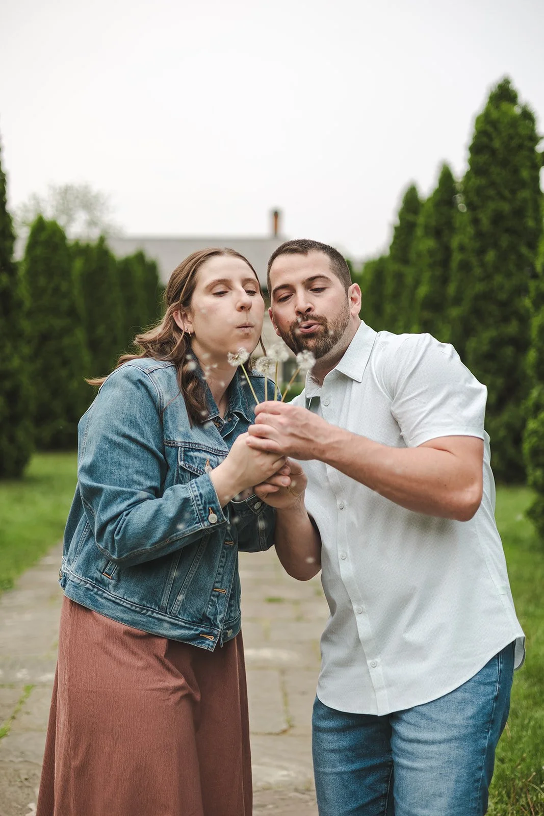 Couple blowing dandelions  Ontario Engagement  Fedora Media.jpg