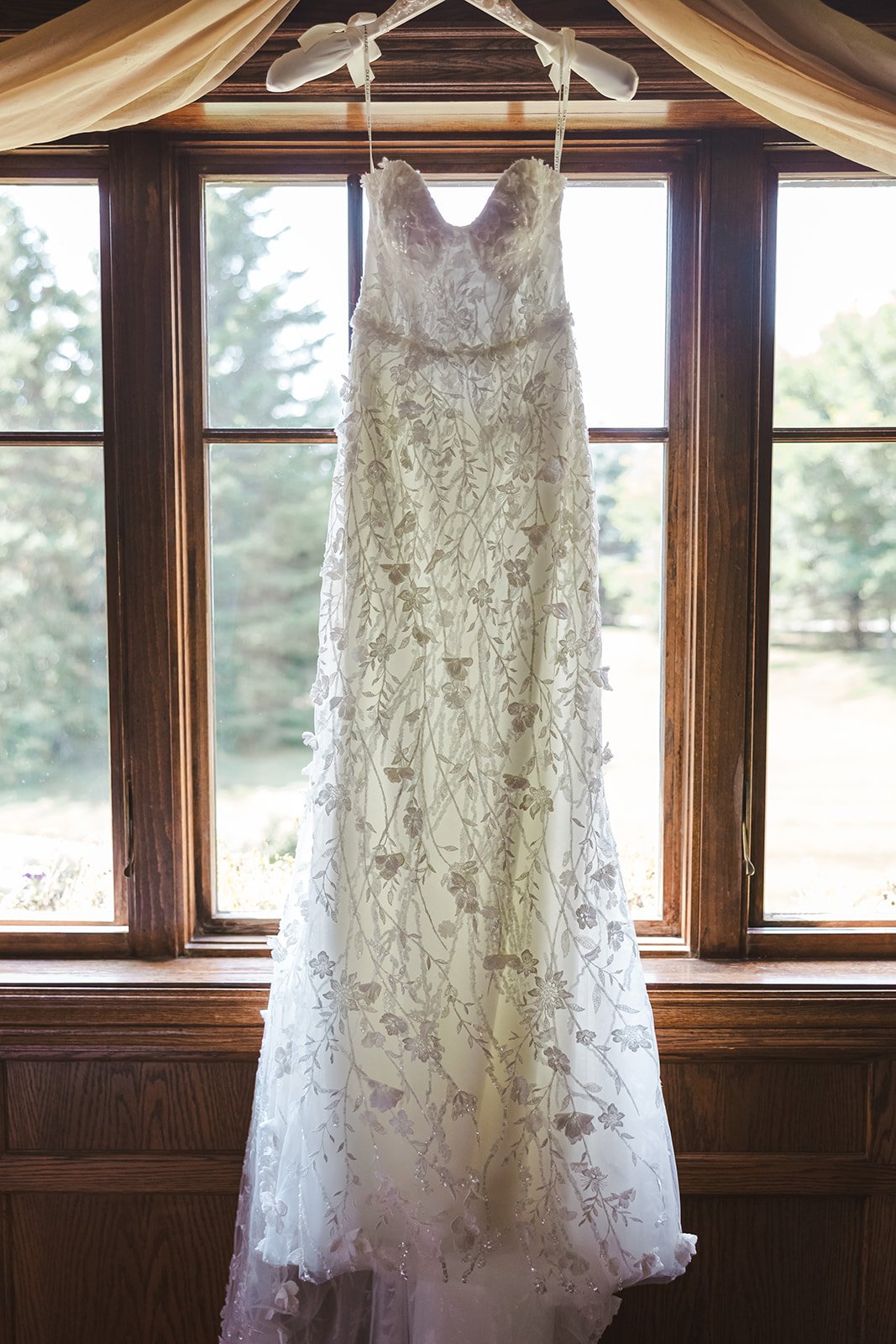 Wedding dress hanging in window  Erin Estates  Fedora Media.jpg
