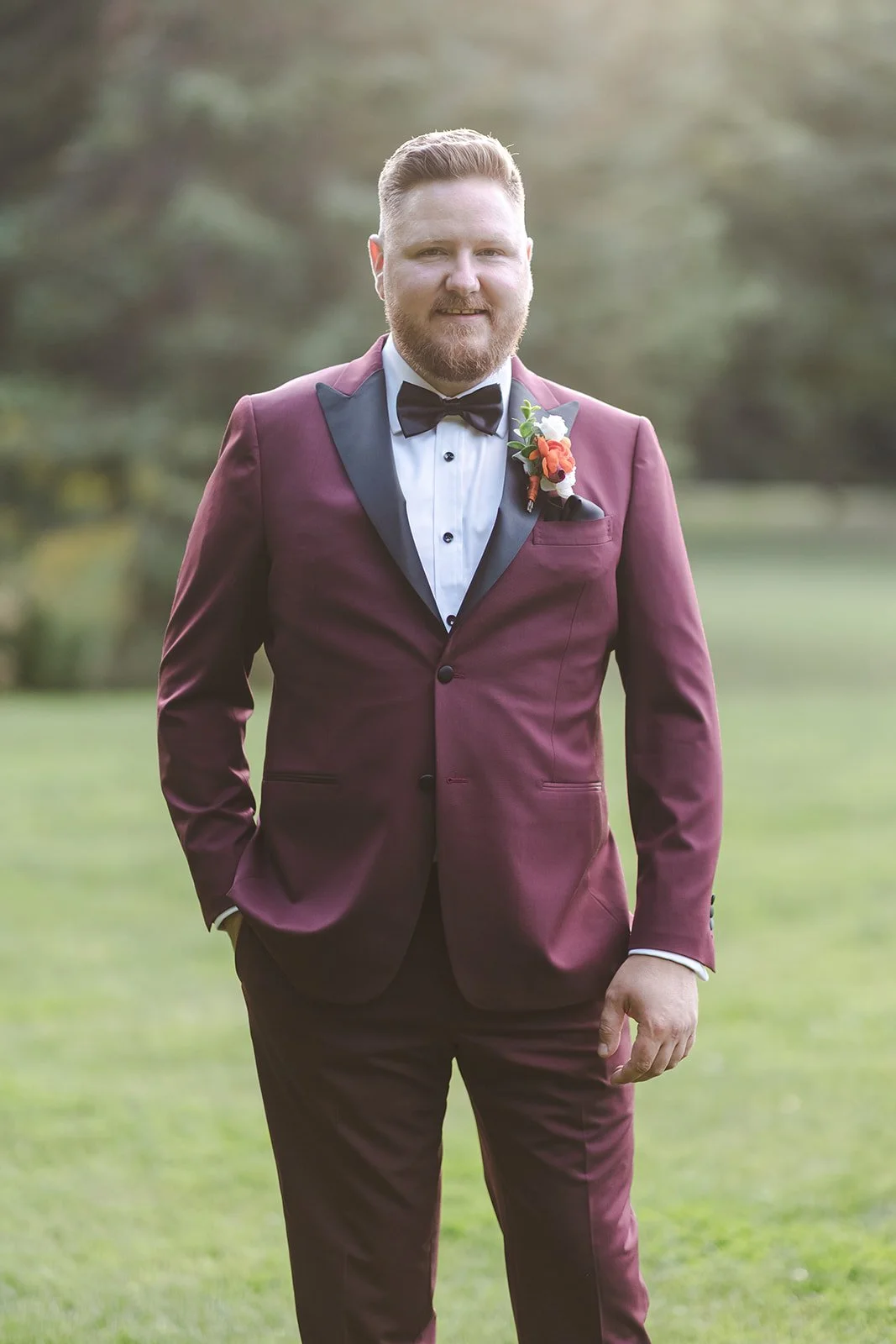 Groom posing alone in grass field  Erin Estates  Fedora Media.jpg