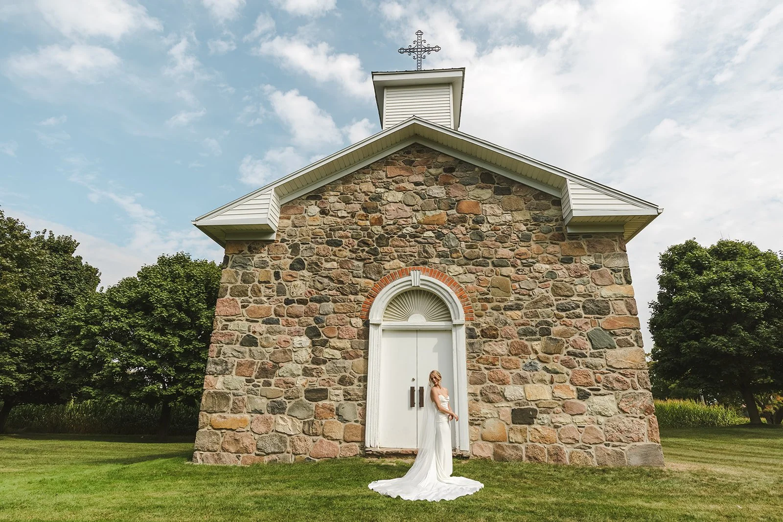 Bride posig in front of stone church  Straford, ON  Fedora Media.jpg