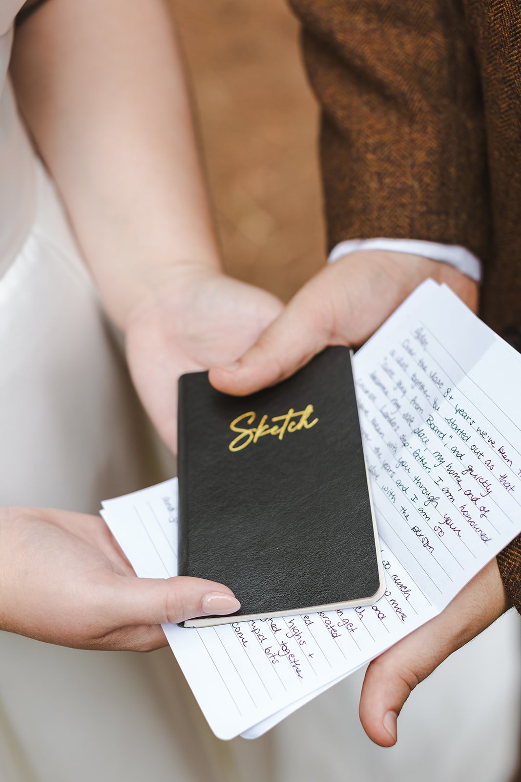 Close up of bride and groom holding written vows  Erin Estates  Fedora Media.jpg
