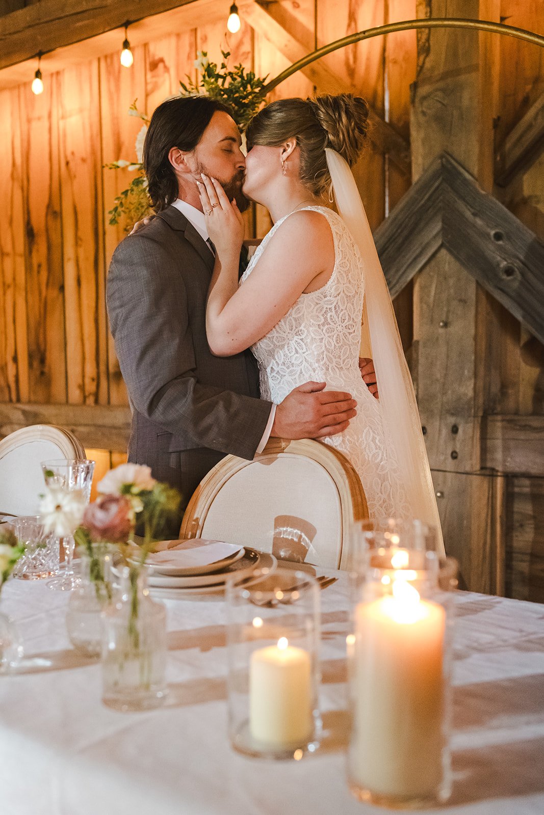Bride and groom kiss behind head table  Cloudnine Alpaca Farm  Fedora Media.jpg